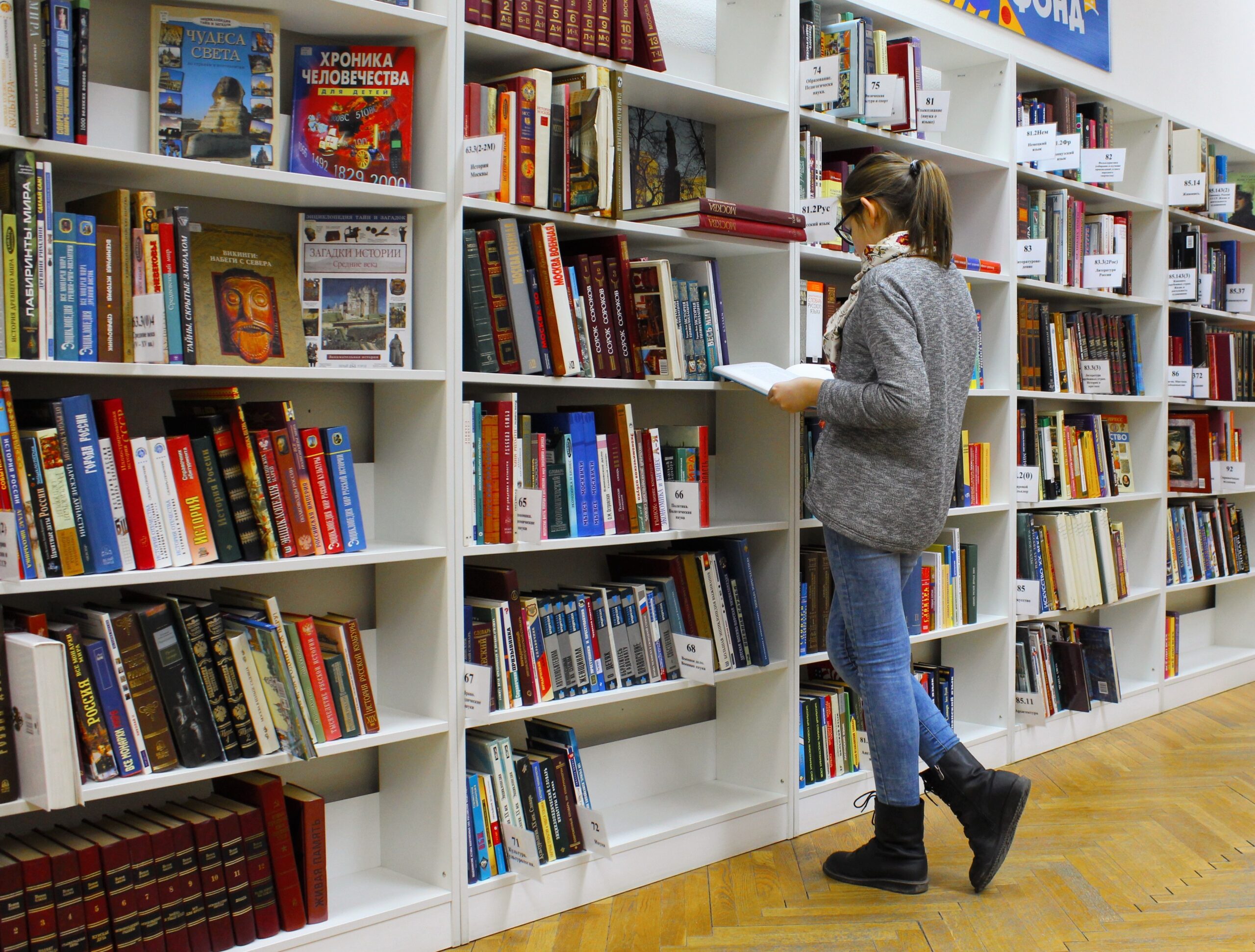 Teen girl standing in front of bookshelves in a library