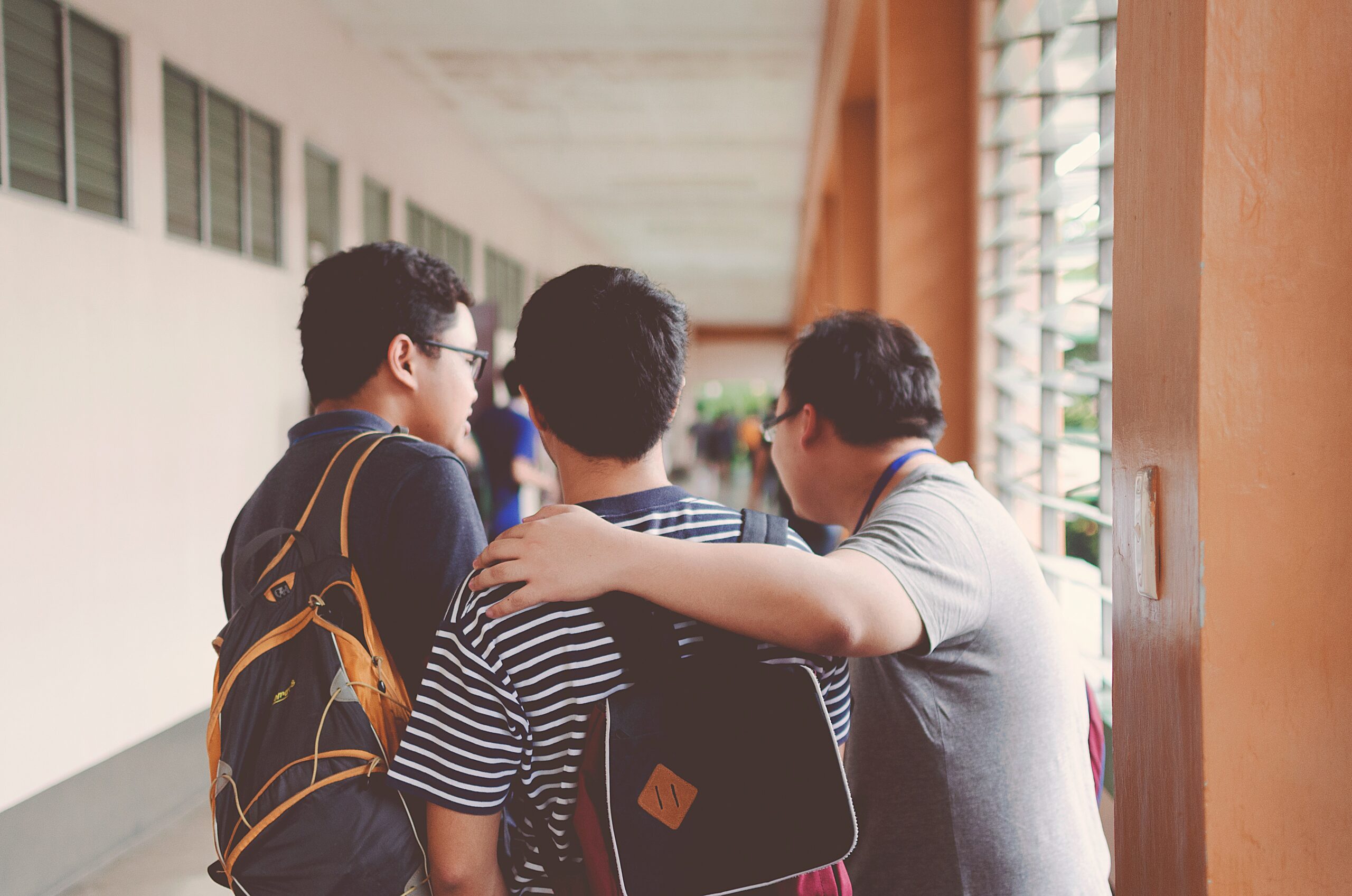 3 boys talking in school hallway